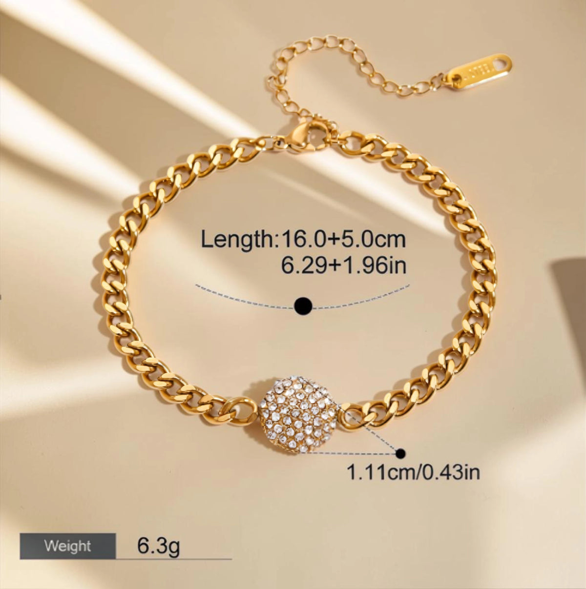 The Orbit Gold Pavé Crystal Ball Chain Bracelet — flat lay on cream surface with lobster clasp and extender chain detail visible