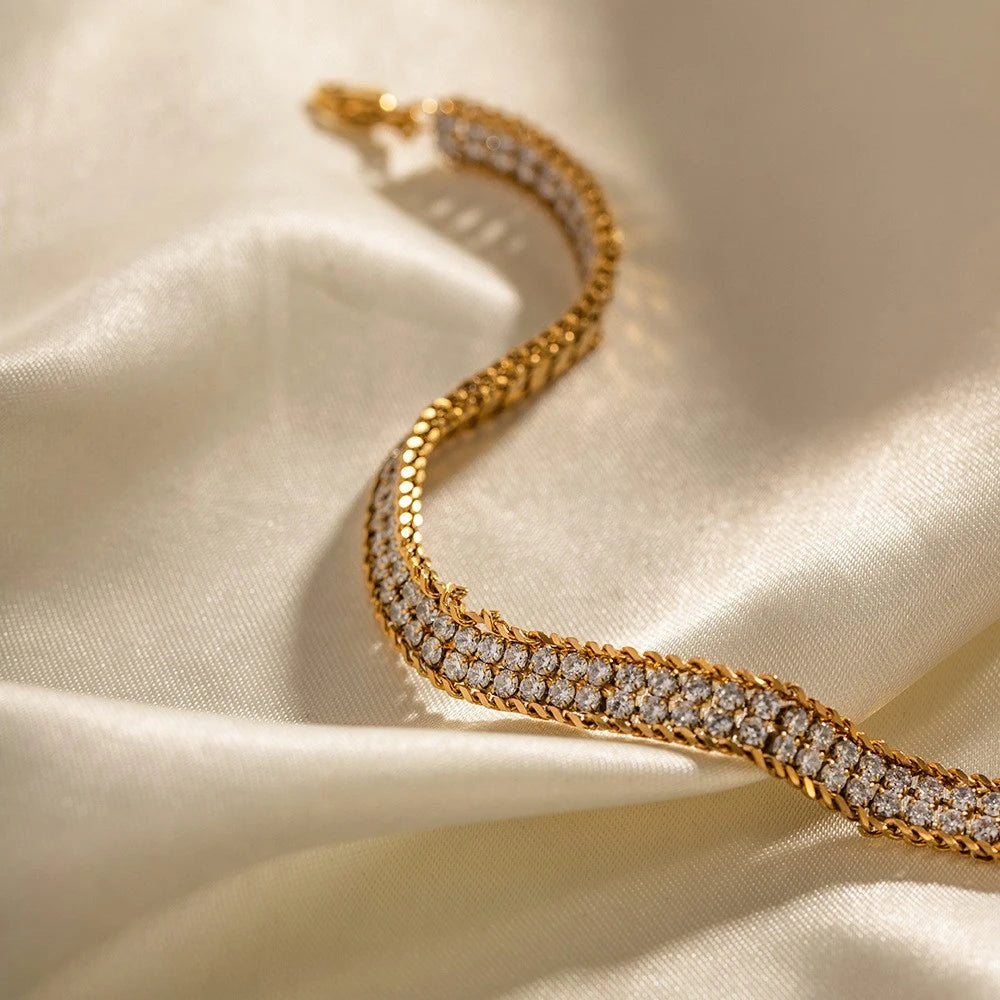 The Armour Gold Crystal-Framed Wide Band Bracelet — worn on wrist showing wide crystal-framed band width and long gold extender chain hanging