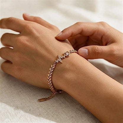 Gold-tone charm bracelet worn on a wrist